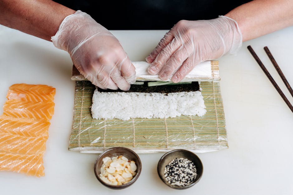 Masanın üzerinde pirinç, nori, sebzeler ve balık dilimleri düzenlenmiş sushi malzemeleri görüntüsü